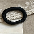 Satin fabric scrunchie in black with pleated texture and soft silk-like finish - Black