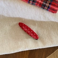 Close-up of red polka dot fabric hair clip with a classic oval shape for girls - Leaf Style