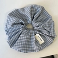 Detailopname van blauw-bruine geruite scrunchie met een handgemaakt stoffen label - Lichtblauw Geblokt