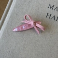 Detailed macro view of pink resin bow hair clip with embedded glitter on fabric book cover - Pink Oval Clip