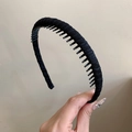 Detalle de una diadema negra antideslizante con dientes finos y textura de tela tejida - Negro
