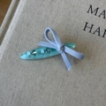Detail of blue resin hair clip featuring sparkling rhinestones and a purple fabric bow - Blue Oval Clip
