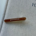 Close-up of amber acetate hair clip with colorful rhinestones and gold engraving - Brown