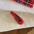 Detail of red polka dot fabric hair clip with a classic BB clip base on textured linen - Hollow Water Drop Style