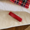 Macro di una molletta per capelli in tessuto rosso a pois bianchi con trama dettagliata - Stile Barra Lunga