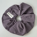Detailed macro view of dark purple matte scrunchie with soft ruffled fabric texture - Purple