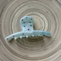 Detail of light blue acetate hair claw clip with colorful rhinestones on wooden tray - Blue