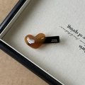 Primer plano de pinza de pelo corazón de acetato ámbar con letras doradas a mano - Marrón