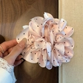 Detail eines rosa Satin-Haargummis mit schwarzen Punkten und Plissee-Design - Rosa Punktmuster