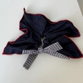 Makroansicht des dunkelblauen Haargummis mit rotem Rand und schwarz-weißem Karomuster - Marineblau Schleife Scrunchie