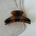 Détail de la pince à cheveux ambrée montrant la texture acrylique brillante et les dents - Écaille de tortue