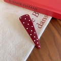 Dettaglio ravvicinato di un fermaglio per capelli bordeaux a pois su tessuto - Stile Triangolo Grande
