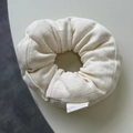Dettaglio di un elastico per capelli in maglia color crema con motivi traforati ed etichetta - Beige Puro