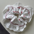 Détail d'un chouchou blanc avec broderie cerise et bords délicats en dentelle fine - Chouchou