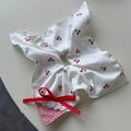 Vue détaillée du chouchou blanc imprimé cerises avec nœud rouge et bordure dentelle - Style Carré de Soie (Chouchou à Nœud)