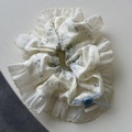Detalle de coletero floral con encaje, lazo azul y etiqueta Hand Made - Coletero Azul