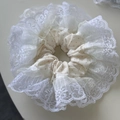 Detailed view of large cream polka dot scrunchie with layered lace and organza trim - Off-white