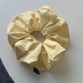 Macro shot of soft cream leather scrunchie with Hand Made label on gray background - Yellow