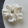 Detail of the soft cream-colored oversized scrunchie with silky pleated texture - Off-white