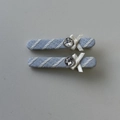 Détail de pinces à cheveux en tissu rayé bleu clair avec nœuds blancs et strass brillants - Paire de Barrettes Rayées Bleues