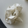 Detailopname van pluizige bloemen scrunchie met geel bloemenpatroon op beige stof - Gele Getailleerde Scrunchie