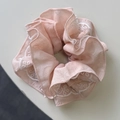 Close-up of pink chiffon hair scrunchie featuring delicate white lace petal embroidery - Pink