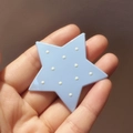 Cute light blue star hair clip with white polka dots held in hand for size reference - Blue Polka Dot Star