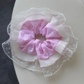 Nahaufnahme eines dreilagigen Spitzen-Haargummis mit rosa Karo und weißem Netzstoff - Rosa