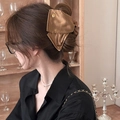 Détail d'une élégante pince à cheveux en tissu doré portée par un mannequin de dos - Marron