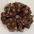 Dettaglio di elastico in organza marrone a pois blu con cuciture sui bordi rifinite - Caffè grande