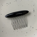 Dettaglio del pettine a 10 denti in metallo con parte superiore in acetato nero e incisione - Nero