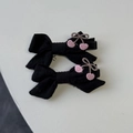 Détail de deux pinces à cheveux en tissu noir avec broderie florale rose au style sucré - Barrette à Nœud Noir