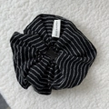 Detailansicht eines schwarz-weiß gestreiften Scrunchies mit Made in Korea Textiletikett - Scrunchie / Schwarz Gestreift