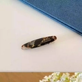 Détail d'une barrette en acétate écaille avec texte France Handmade et pince en métal - Marron Texturé