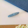 Dettaglio di un fermaglio per capelli in acetato blu marmorizzato con scritta dorata - Blu