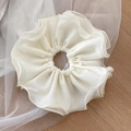 Detailed close-up of cream chiffon scrunchie with layered ruffles and delicate wavy edges - Off-white