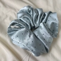 Detailed macro shot of light blue satin polka dot scrunchie with silky texture - Blue