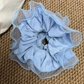 Detalle de coletero azul claro con capas de tela de organza y bordes de volantes finos - Azul