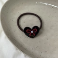 Nahaufnahme eines schwarzen Acetat-Haargummis mit roter Schleife und glitzerndem Kristall - Schwarz