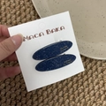 Detail view of navy blue acetate hair clips with silver glitter on display card - Blue