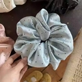 Detailed view of oversized satin scrunchies with black polka dots in various colors - Blue