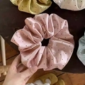 Macro shot of large polka dot silk scrunchies in pastel colors on wooden surface - Pink