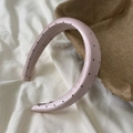 Close-up of pink satin headband with black polka dots on white draped fabric - Wide Headband / Pink