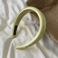 Close-up of a lime yellow polka dot satin headband with thick padded design on linen - Wide Headband / Yellow