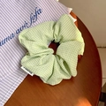 Detail van de lichtgroene ruitjes scrunchie op houten tafel met stijlvol label - Groen