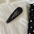 Dettaglio macro della clip per capelli francese vintage in raso a pois bianchi e neri - Nero