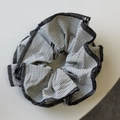 Détail rapproché d'un chouchou en tissu à rayures noires et blanches avec bords cousus - Noir