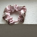 Detail of pink satin scrunchie with white edges and polished oval decorative bead - Pink