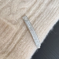 Close-up of silver glitter hair clip with heart and fair mood engraving on beige sweater - Silver