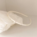 Detail showing colorful rhinestones and non-slip teeth on cream thin headband - Off-white
